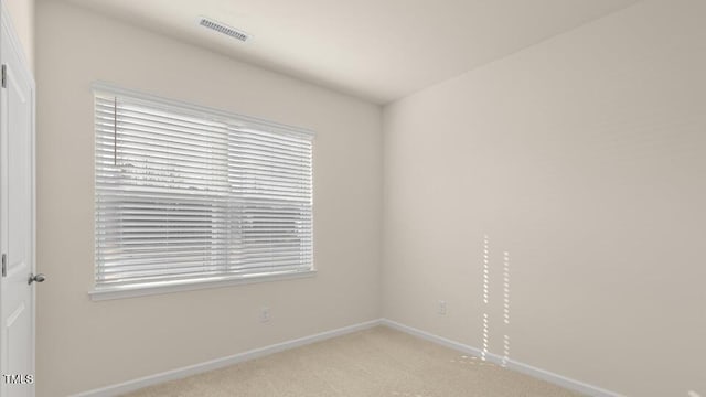 unfurnished room with light carpet, visible vents, and baseboards