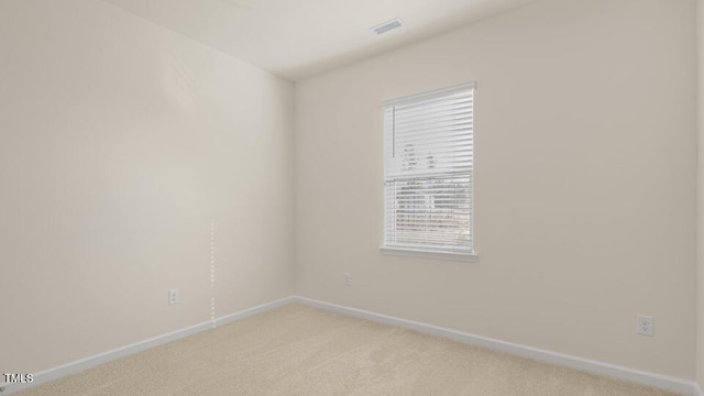 spare room with light carpet, visible vents, and baseboards