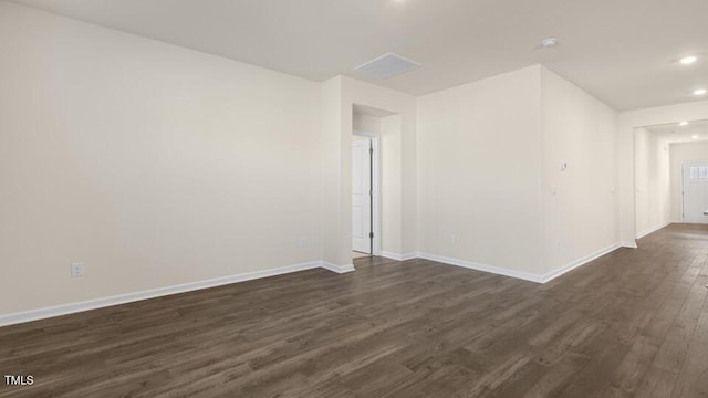 spare room featuring baseboards, dark wood-style flooring, and recessed lighting