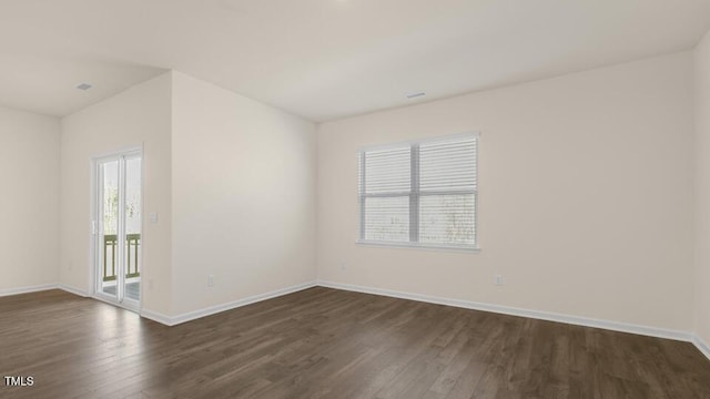 empty room with dark wood-style flooring and baseboards