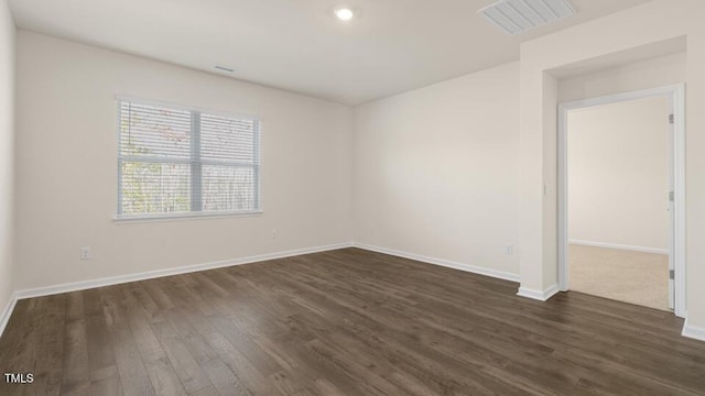 empty room with dark wood-type flooring, recessed lighting, visible vents, and baseboards