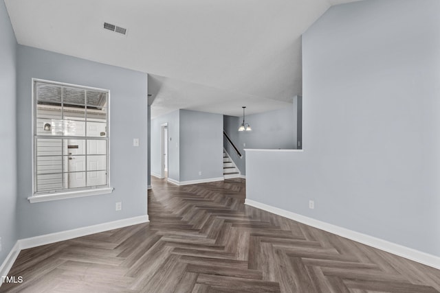 empty room with stairway, visible vents, and baseboards