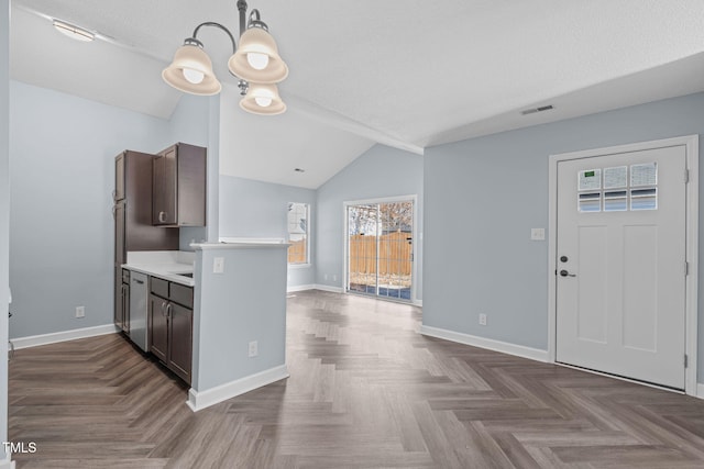 kitchen featuring lofted ceiling, baseboards, light countertops, and dark brown cabinets