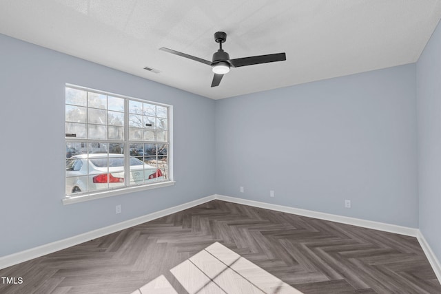 unfurnished room with visible vents, ceiling fan, a textured ceiling, and baseboards