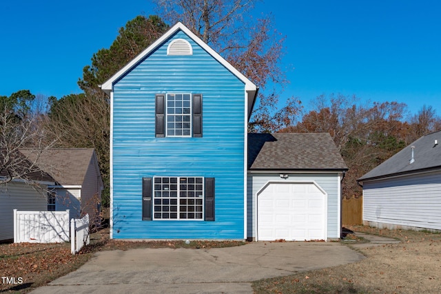 view of front facade with a garage and a shingled roof