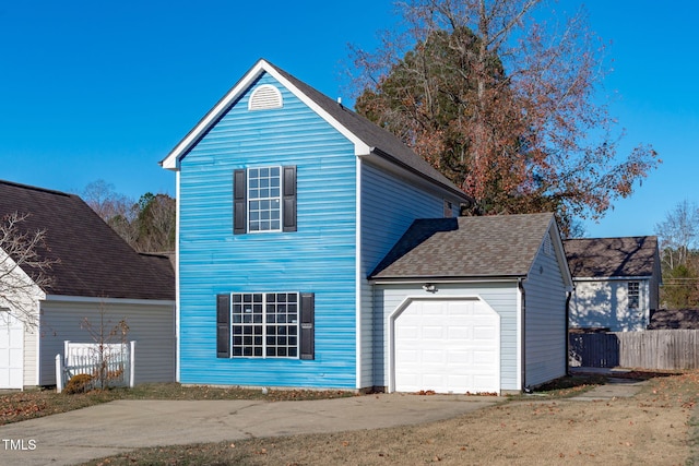 view of front of house featuring an attached garage and fence