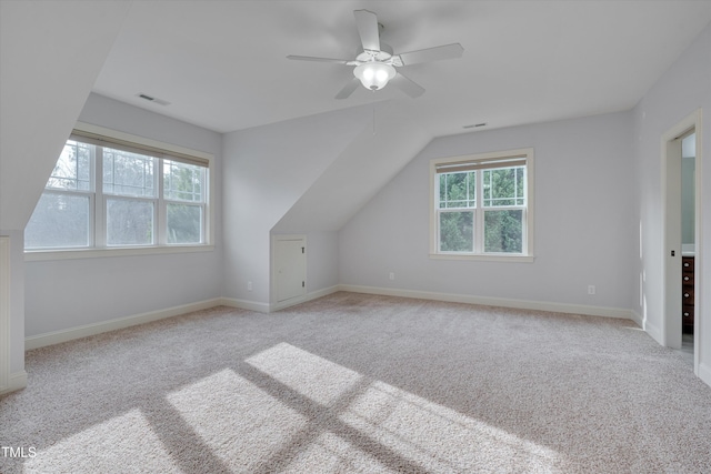 additional living space with lofted ceiling, visible vents, light carpet, ceiling fan, and baseboards