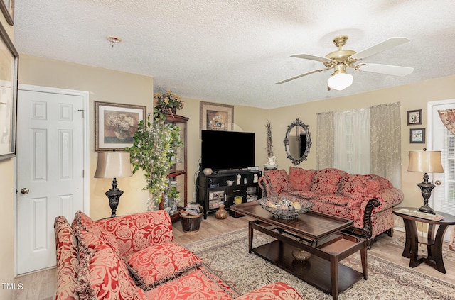 living area featuring a textured ceiling, ceiling fan, and wood finished floors