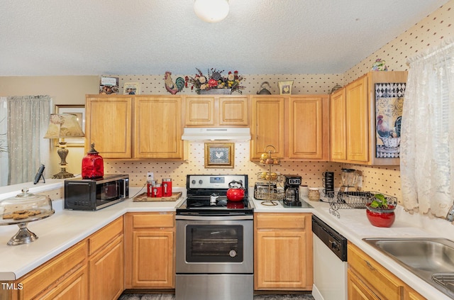 kitchen with a sink, light countertops, under cabinet range hood, a textured ceiling, and appliances with stainless steel finishes