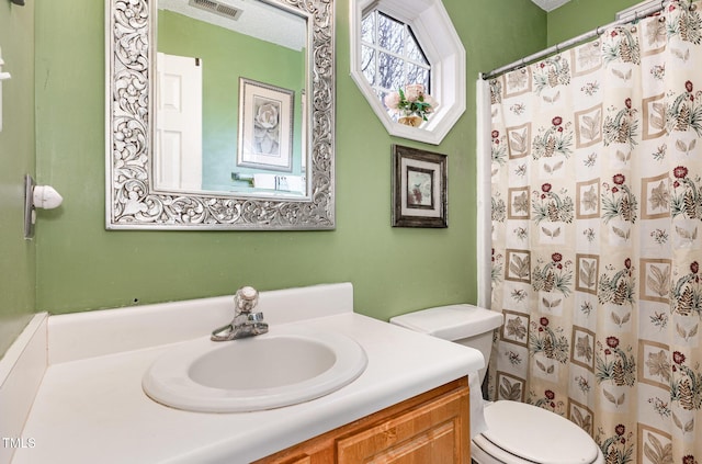 full bathroom with visible vents, toilet, curtained shower, a textured ceiling, and vanity