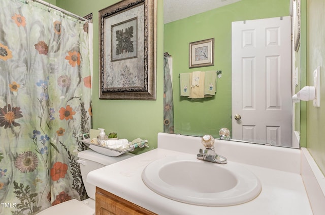 bathroom featuring vanity, a shower with shower curtain, toilet, and a textured ceiling