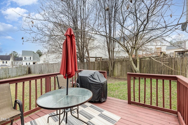 wooden terrace featuring area for grilling, a fenced backyard, and a lawn