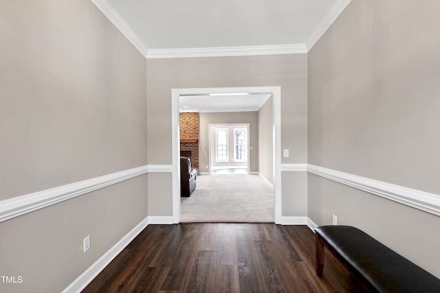 corridor with ornamental molding, dark wood finished floors, and baseboards