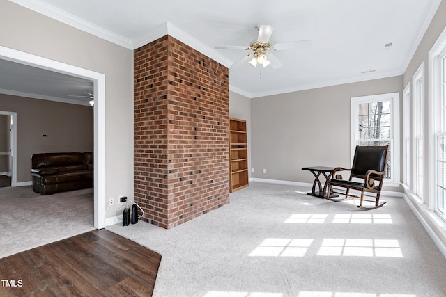 living area featuring carpet floors, baseboards, and crown molding