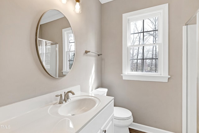 full bathroom with a shower with shower door, vanity, toilet, and baseboards