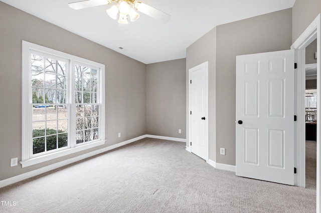 unfurnished bedroom with carpet floors, visible vents, baseboards, and a ceiling fan