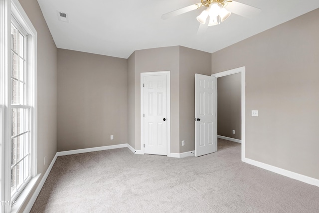 unfurnished bedroom featuring ceiling fan, carpet floors, visible vents, and baseboards