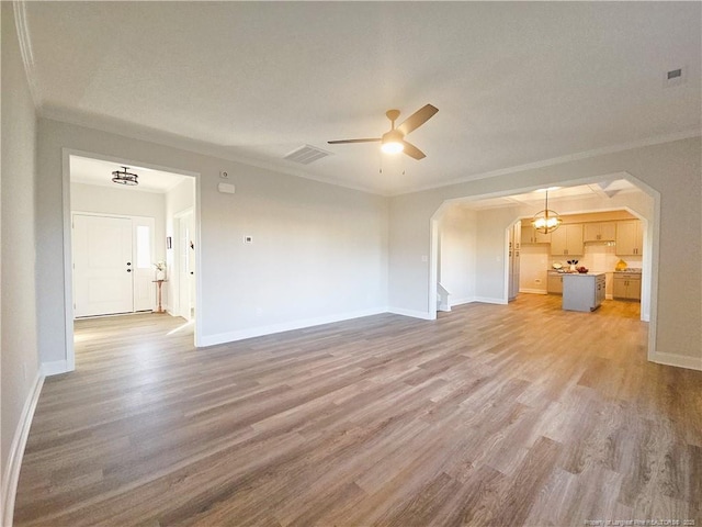 unfurnished living room featuring crown molding, hardwood / wood-style flooring, and ceiling fan