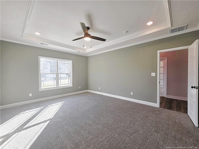 carpeted spare room with a tray ceiling, ceiling fan, and crown molding