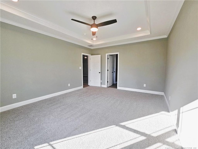 carpeted empty room with a tray ceiling, crown molding, and ceiling fan