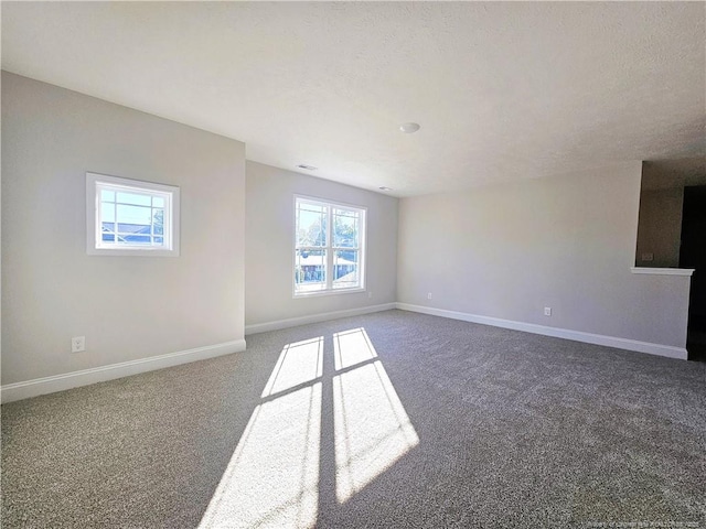 spare room featuring dark colored carpet