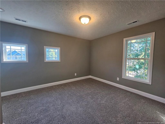 carpeted spare room featuring a textured ceiling