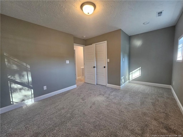 unfurnished bedroom with carpet floors and a textured ceiling