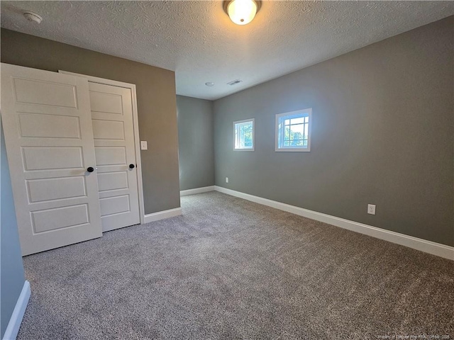 unfurnished bedroom featuring carpet floors and a textured ceiling