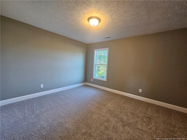 empty room featuring carpet and a textured ceiling