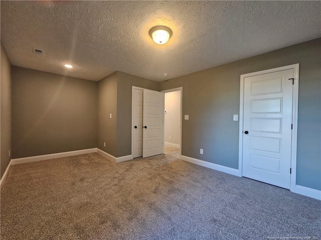 unfurnished bedroom featuring carpet and a textured ceiling