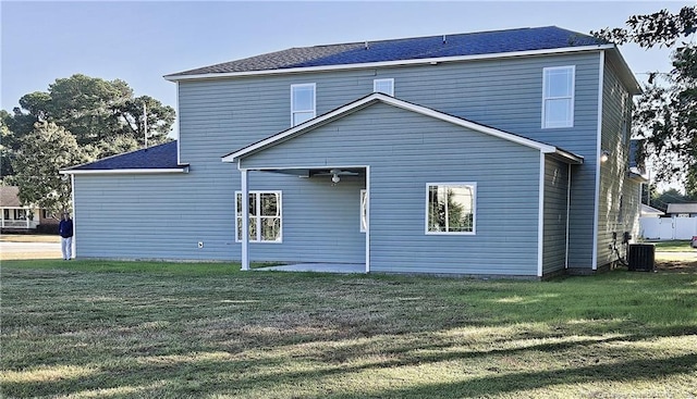 back of house with a yard and central air condition unit