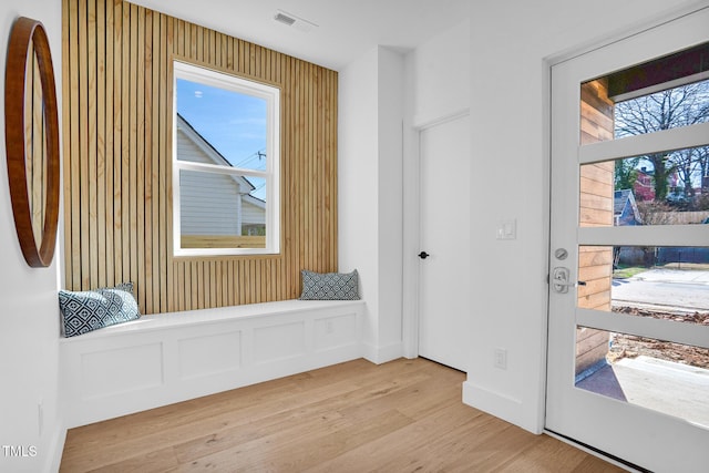 interior space featuring light wood-type flooring, a healthy amount of sunlight, and visible vents