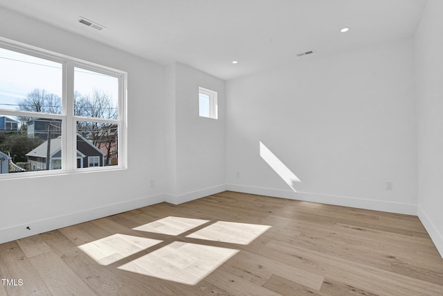 unfurnished room with light wood finished floors, baseboards, visible vents, and recessed lighting