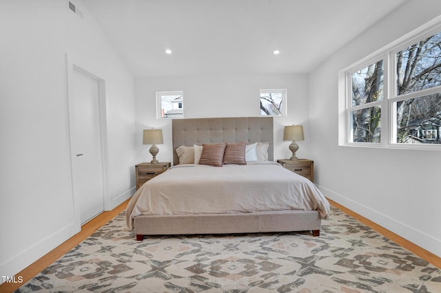 bedroom featuring multiple windows, visible vents, and wood finished floors