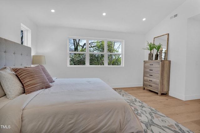 bedroom featuring baseboards, visible vents, vaulted ceiling, light wood-type flooring, and recessed lighting