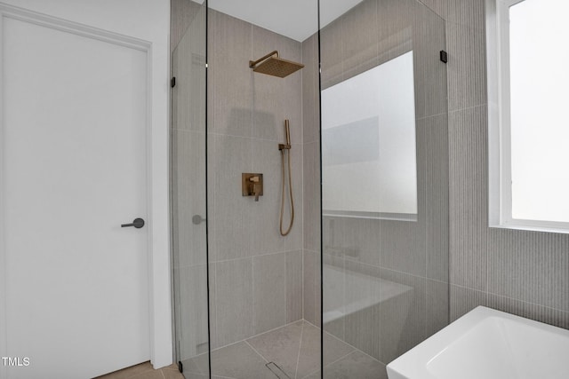 bathroom with walk in shower and a freestanding bath