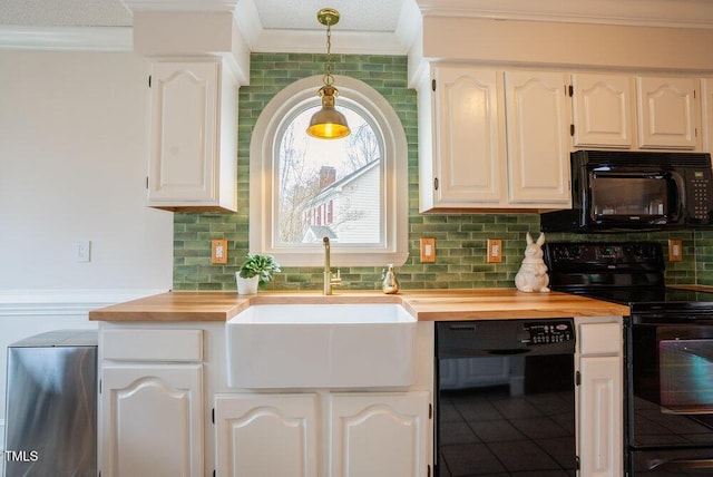 kitchen with pendant lighting, black appliances, butcher block counters, and white cabinets