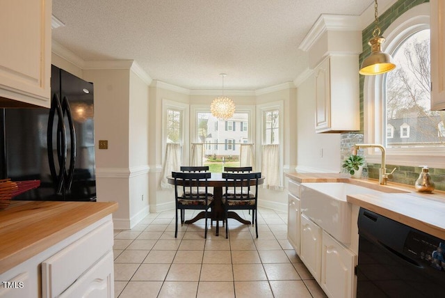 kitchen with tasteful backsplash, ornamental molding, black appliances, pendant lighting, and light tile patterned flooring