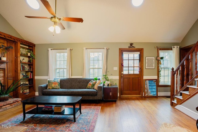 living room with lofted ceiling, ceiling fan, stairs, and wood finished floors