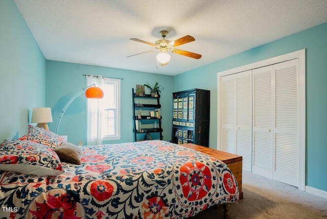 bedroom with carpet, a closet, a ceiling fan, a textured ceiling, and baseboards