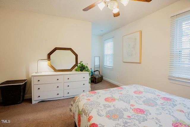 bedroom with light carpet, multiple windows, a ceiling fan, and baseboards