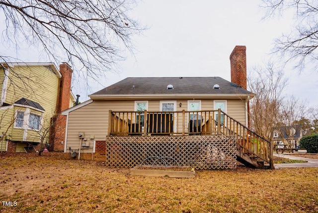 rear view of property with a chimney, a deck, and stairs