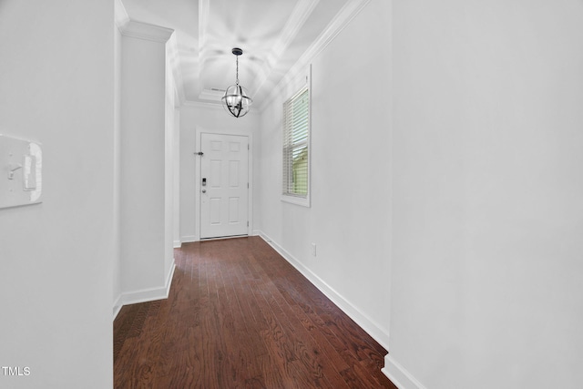 corridor featuring baseboards, a chandelier, dark wood-style flooring, and crown molding