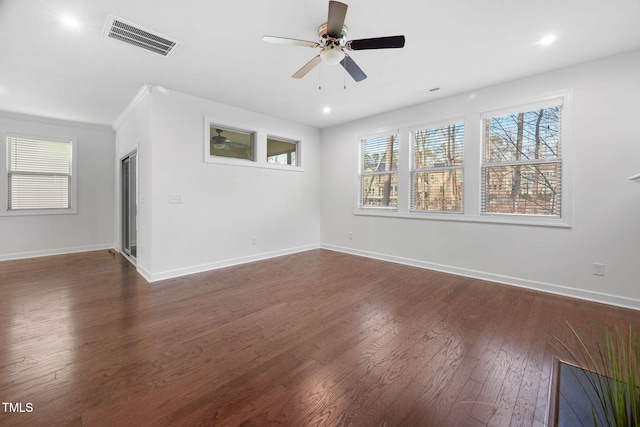 unfurnished room featuring baseboards, visible vents, dark wood finished floors, and a ceiling fan