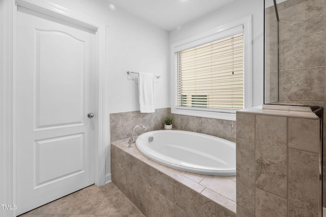 bathroom with tile patterned floors and a bath