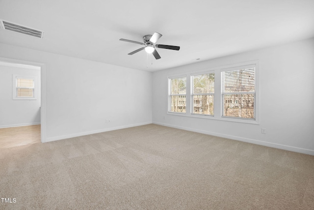 unfurnished room with light carpet, baseboards, visible vents, and ceiling fan