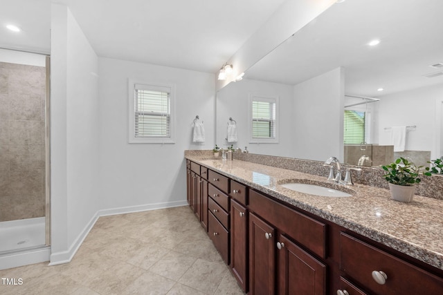 full bathroom with a sink, a shower stall, baseboards, and double vanity