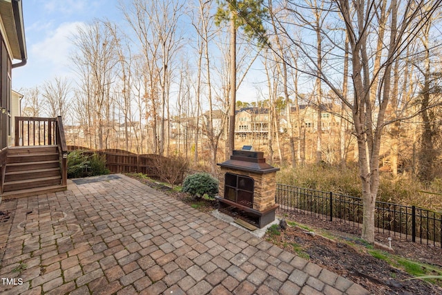 view of patio with an outdoor fireplace and a fenced backyard