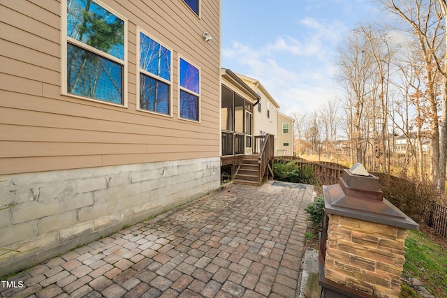 view of home's exterior with a patio area and fence