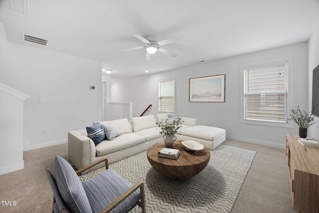 living area featuring a ceiling fan, visible vents, light carpet, and baseboards